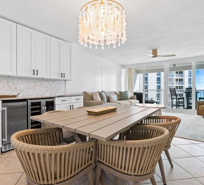 Unwind in your open-concept retreat where elegant dining flows into coastal comfort beneath a stunning chandelier.