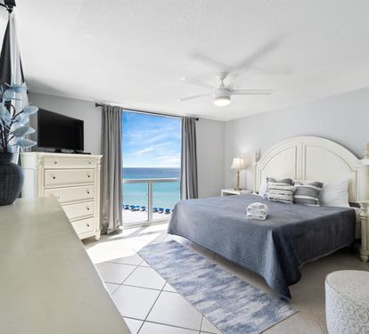 Wake up to endless ocean views from your private balcony. Crisp white linens and coastal blues create your perfect seaside retreat.