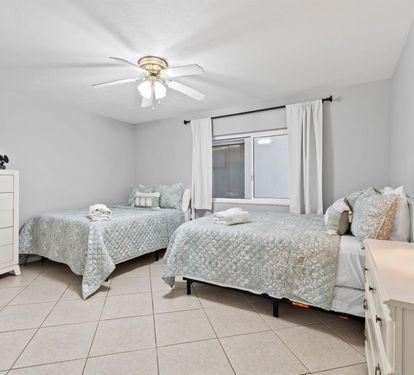 Rest comfortably in your spacious twin bedroom with soft linens, ceiling fan, and TV for peaceful nights.