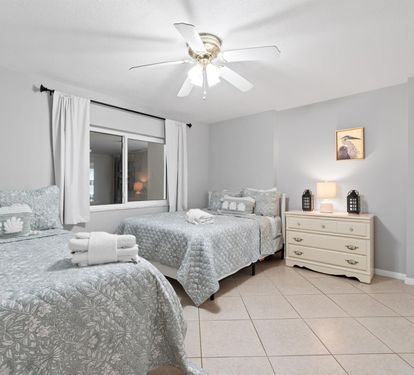 Your peaceful twin bedroom features comfortable beds with soft linens, gentle ceiling fan, and warm lighting for restful nights.