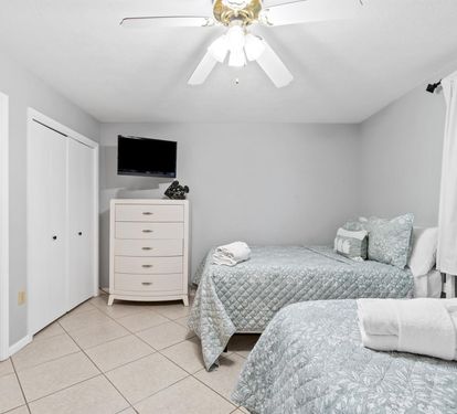 Your peaceful bedroom features twin beds with soft linens, wall-mounted TV for relaxation, and ample wardrobe storage for your belongings.