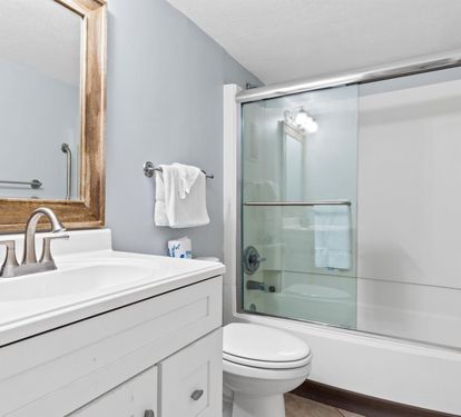 Fresh towels await you in this pristine bathroom with a spacious shower and modern amenities for your comfort.