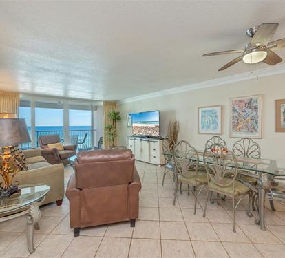 Unwind in your elegant oceanfront living space where coastal artwork and comfortable seating create the perfect retreat for relaxing.