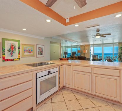 Your bright kitchen features granite counters, modern appliances, and stunning ocean views through the open floor plan.