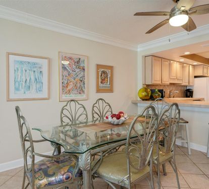 Your elegant dining space features a glass table perfect for family meals, complemented by an open kitchen design.