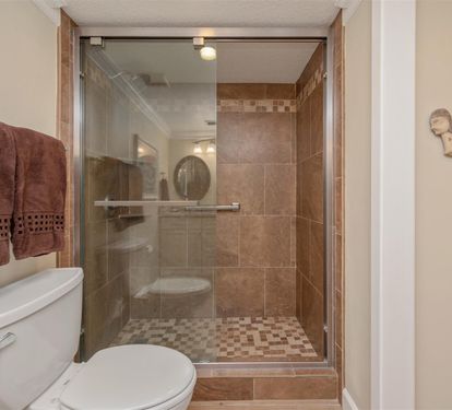 Step into your spa-like bathroom where warm earth tones and elegant tile work create a peaceful retreat for refreshing after beach days.