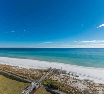 Stunning beachfront location with pristine white sand and crystal-clear waters stretching to the horizon.