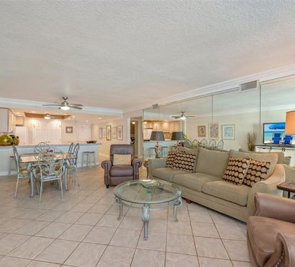 Relax in your spacious open-concept living area with comfortable seating, a fully equipped kitchen, and elegant glass dining table perfect for memorable meals together.