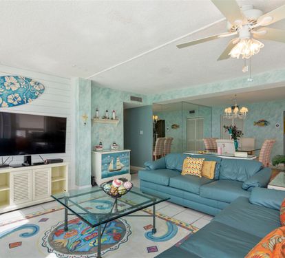 Relax in your tropical-themed living room with ocean blues, cozy seating, and beachy decor creating the perfect coastal retreat ambiance.