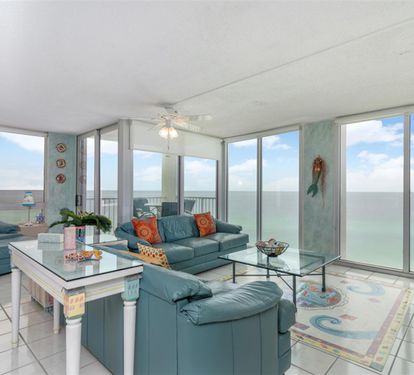 Relax in your oceanfront living room where floor-to-ceiling windows frame endless sea views. Sink into comfortable seating while watching waves from your private retreat.