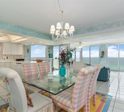 Enjoy breathtaking ocean views while dining in your elegant space with glass table and designer chandelier.