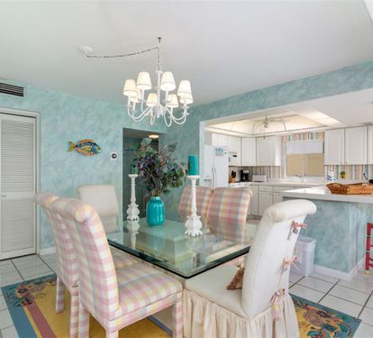Your bright coastal dining area flows seamlessly into a fully-equipped kitchen, perfect for memorable meals together.