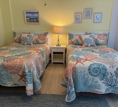 Drift off in comfort with twin beds dressed in coastal-themed linens featuring coral and starfish patterns that'll transport you to the seaside.