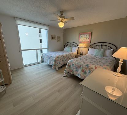 Rest peacefully in your comfortable double bedroom with ocean views through floor-to-ceiling windows and gentle ceiling fan for perfect climate.