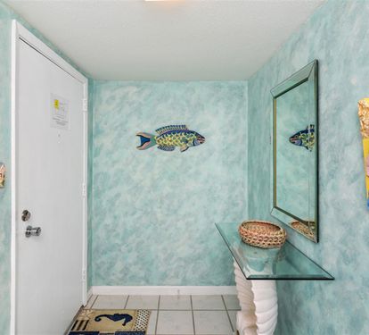 Your beachside getaway starts here! Aqua-blue walls with tropical fish art welcome you into your coastal retreat.
