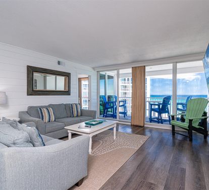 Unwind in your stylish living space with plush seating and stunning ocean views through floor-to-ceiling windows.