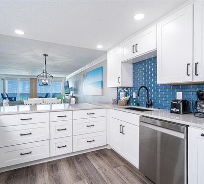 You'll love cooking in this bright, modern kitchen with stunning blue tile backsplash and ocean views beyond.