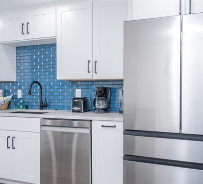 Your fully equipped kitchen features stainless steel appliances and stunning blue tile backsplash, perfect for preparing meals during your stay.
