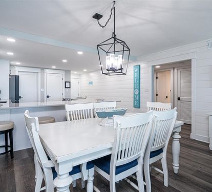 Gather around this bright dining space where white coastal charm meets modern comfort for memorable meals together.