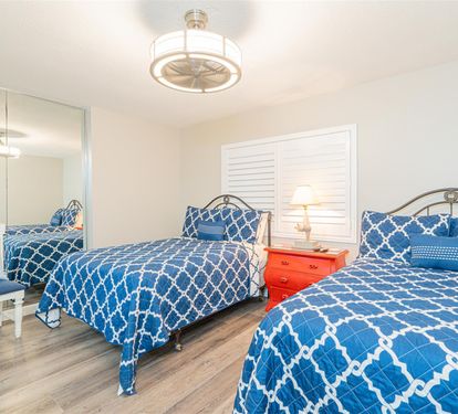 Rest easy in your coastal bedroom featuring twin beds with cheerful blue patterns and nautical touches.