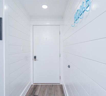 Step into your coastal retreat through this bright, welcoming entryway with charming shiplap walls and cheerful nautical touches.