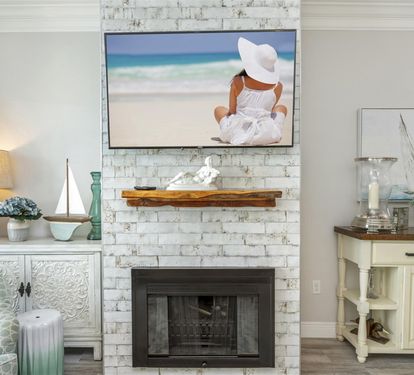 Relax in your serene living space where coastal charm meets comfort, with a cozy fireplace and beach-inspired décor creating your perfect seaside retreat.