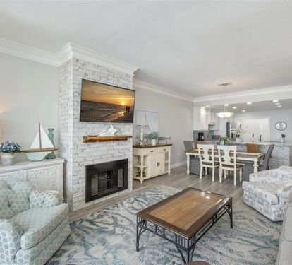 Unwind in your elegant coastal retreat, where a cozy fireplace and open living flow perfectly into your fully equipped kitchen—ideal for memorable evenings together.