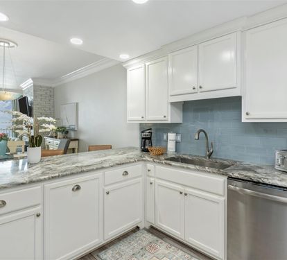 Your elegant kitchen features granite countertops, crisp white cabinets, and modern appliances—perfect for preparing memorable meals during your stay.