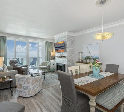 Relax in your elegant living space with ocean balcony access, cozy fireplace, and open dining area perfect for memorable meals.