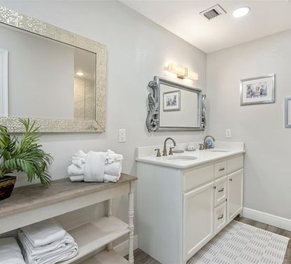 Unwind in your elegant bathroom featuring dual vanities, spa-like lighting, and fluffy towels ready for your relaxation.