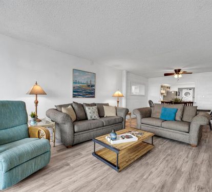 Settle into this spacious living room where coastal colors and comfy seating create your perfect retreat for relaxation.