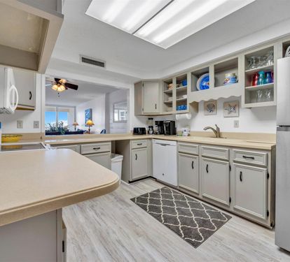Your spacious kitchen features everything you need - dishwasher, microwave, coffee maker, and ocean views through the window.