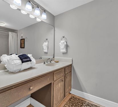 Your private bathroom features a spacious vanity with plenty of counter space, fresh towels, and bright vanity lighting for your morning routine.