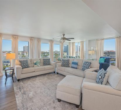 Unwind in your spacious living room with panoramic city views through floor-to-ceiling windows and comfortable seating for the whole group.