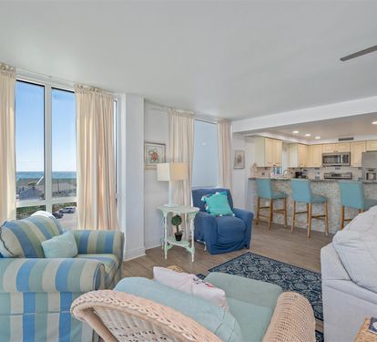 Sink into soft coastal furniture while ocean views fill your windows in this bright, airy living space.