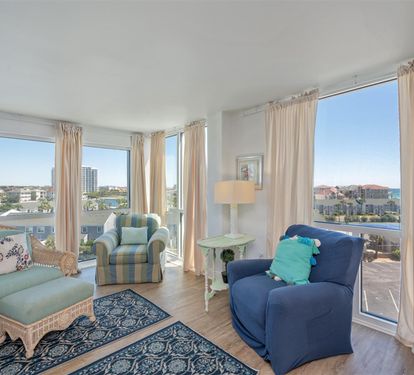 Sink into coastal comfort in your light-filled living room with panoramic city views stretching to the horizon through floor-to-ceiling windows.