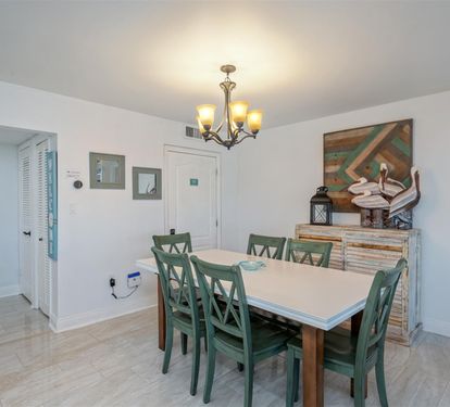 Gather around your spacious dining table for memorable meals, bathed in warm light from the elegant chandelier above.