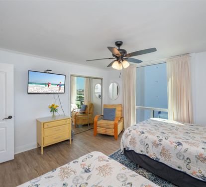 Unwind in your bright, cheerful bedroom with twin beds, cozy seating area, and private balcony access for morning coffee or evening relaxation.