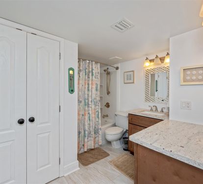 Step into your spacious bathroom featuring a luxurious granite countertop, stylish vanity lighting, and a relaxing tub-shower combo.