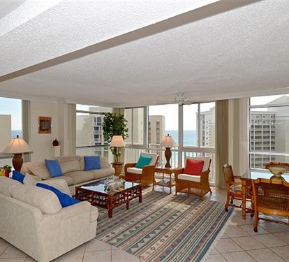 Your spacious living room features floor-to-ceiling windows showcasing stunning city views, comfortable seating, and warm lighting for perfect relaxation.
