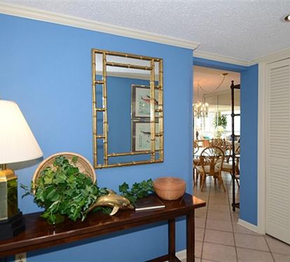 Your bright entryway welcomes you with coastal blue walls and elegant decor, setting a relaxing tone for your stay.