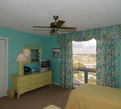 Wake up to stunning city views from your bright, tropical-themed bedroom with comfortable furnishings and modern amenities.