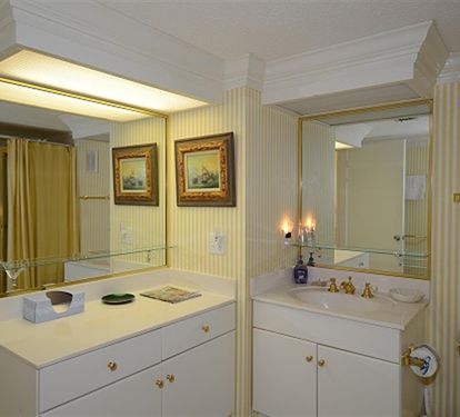 Relax in your elegant bathroom with dual vanities and warm lighting creating the perfect atmosphere for your daily routine.