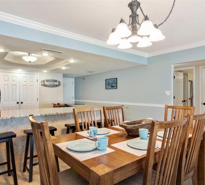 Gather around your spacious dining table where warm wood and soft blue walls create the perfect backdrop for memorable meals together.
