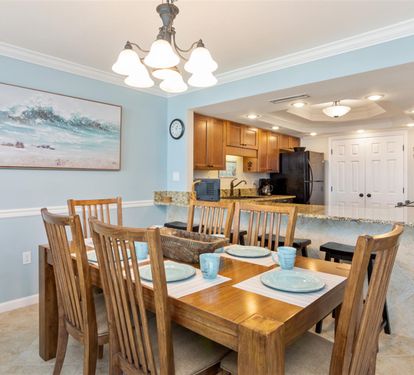 Gather around your spacious dining table where coastal artwork and soft blue walls create the perfect backdrop for memorable meals together.