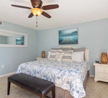 Drift into peaceful dreams in your serene coastal bedroom, where soft blue walls and ocean artwork create a tranquil retreat.