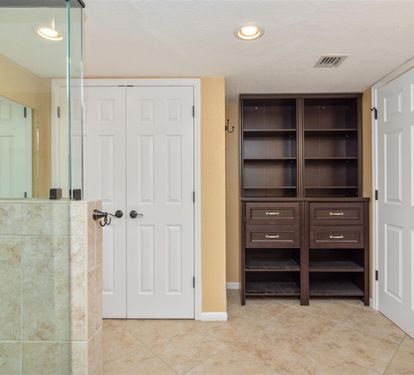 Luxurious bathroom with spacious glass shower, elegant built-in cabinetry, and warm tile floors for your ultimate relaxation retreat.