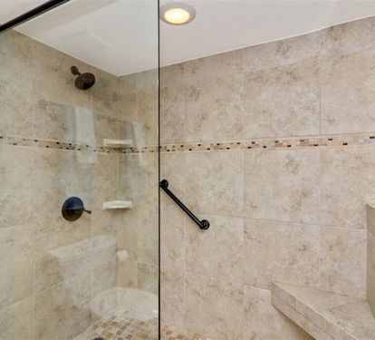 Step into your spacious walk-in shower with beautiful travertine tile and modern fixtures—your private sanctuary awaits.