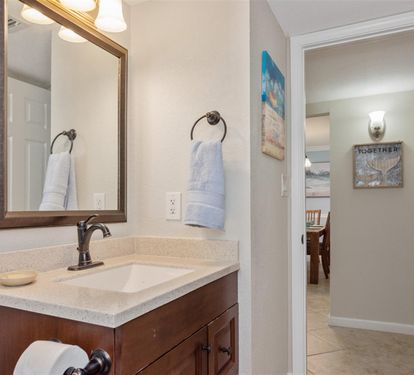 Step into your private bathroom with fresh towels waiting for you, complete with a spacious vanity and soothing coastal decor.