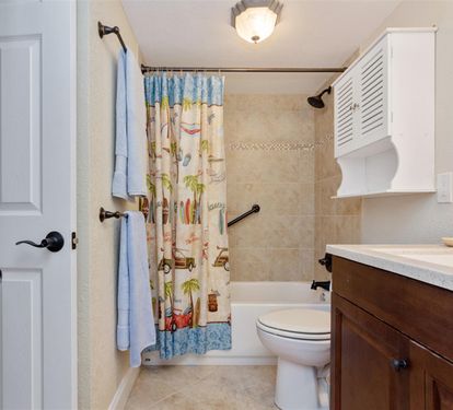 Your bathroom features a tub-shower combo with cheerful decor and essential amenities for your comfort.